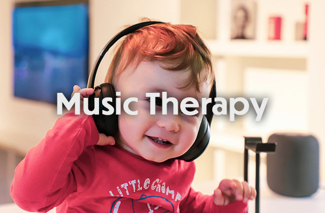 A young boy smiles while listening to music with headphones.