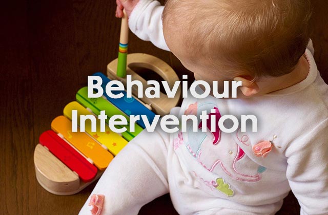 An infant plays with a toy xylophone.