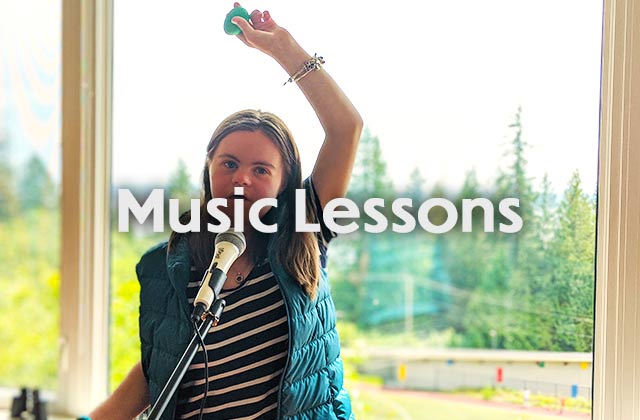 A young girl with one arm in the air, sings into a microphone.